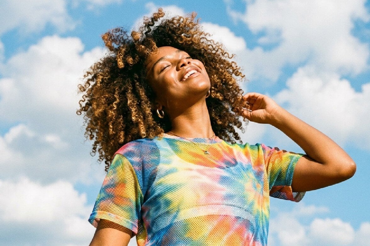 An enhanced image of a black woman wearing a colorful top after upscaling the resolution with fotor ai image upscaler